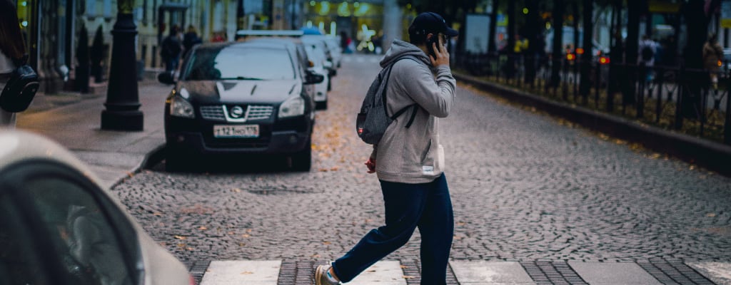 Mężczyzna na przejściu dla pieszych rozmawia przez telefon